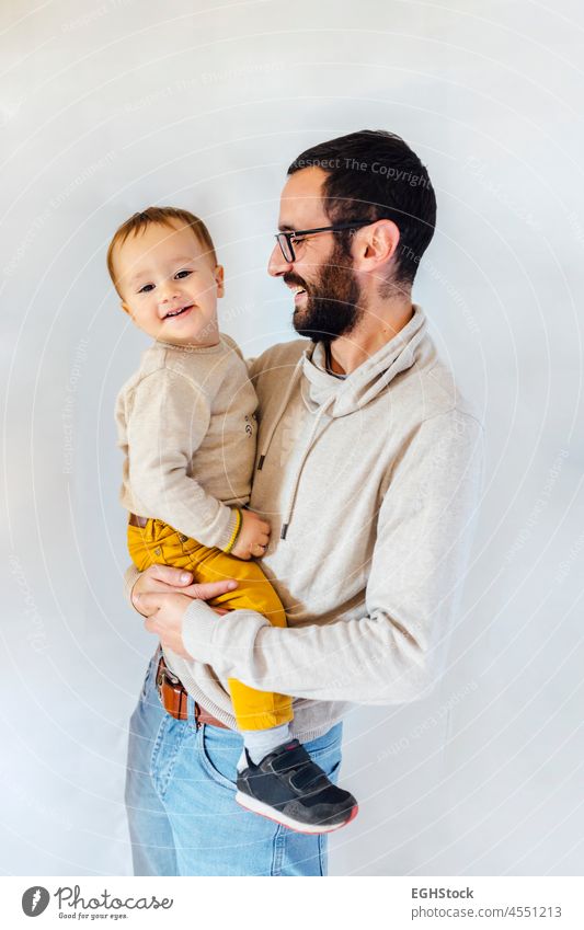 Young father with his son in arms on white background. Father and baby concept. holding dad latin happy man isolated adorable hispanic beautiful boy cheerful