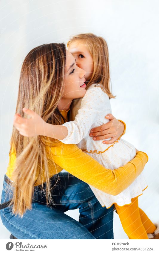 business mother hugging her daughter on white background. Young hispanic woman. Mum and daughter concept. mom work toddler empower empowering kiss motherhood