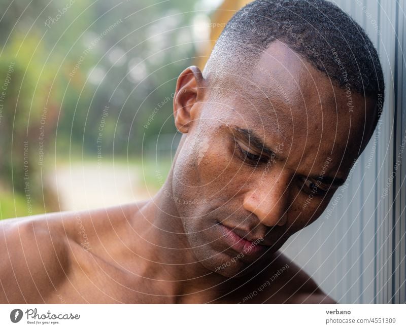 portrait of an young topless athetic african man outdoors afro american male expression shirtless hands muscular muscled emotion posing model grey background