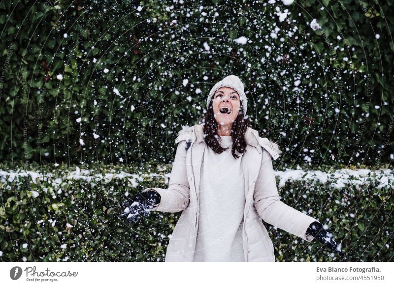cheerful caucasian young woman playing outdoors with snow and snowflakes, fun and winter lifestyle park mountain snow flake snowing leisure happy smiling 30s