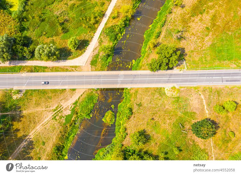 aerial drone shoot. Flying over a beautiful green forest in a rural landscape. Top view of trees in forest background. Drone photography. Forest river, rural road.