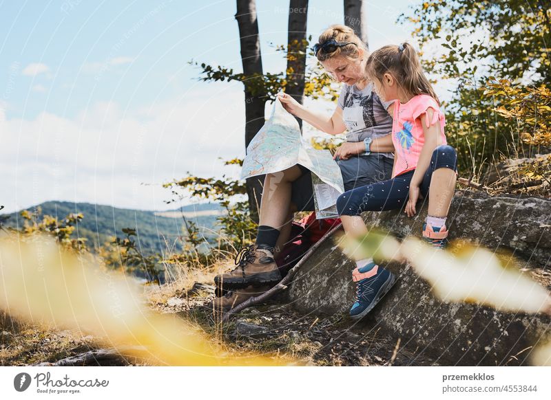Family trip in mountains. Mother and her daughter examining a map vacation summer hike family travel active trail activity caucasian child enjoy fun girl real