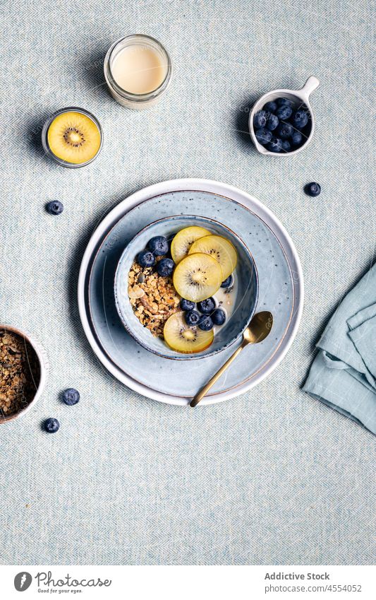Breakfast with bowl of granola and healthy kiwi and blueberries breakfast blueberry morning food portion tea meal tasty ceramic delicious fresh muesli table
