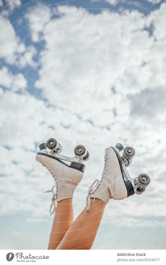 Legs of unrecognizable roller skater woman street sportive hobby activity healthy lifestyle leg raised wellbeing blue sky cloud female workout summer wellness