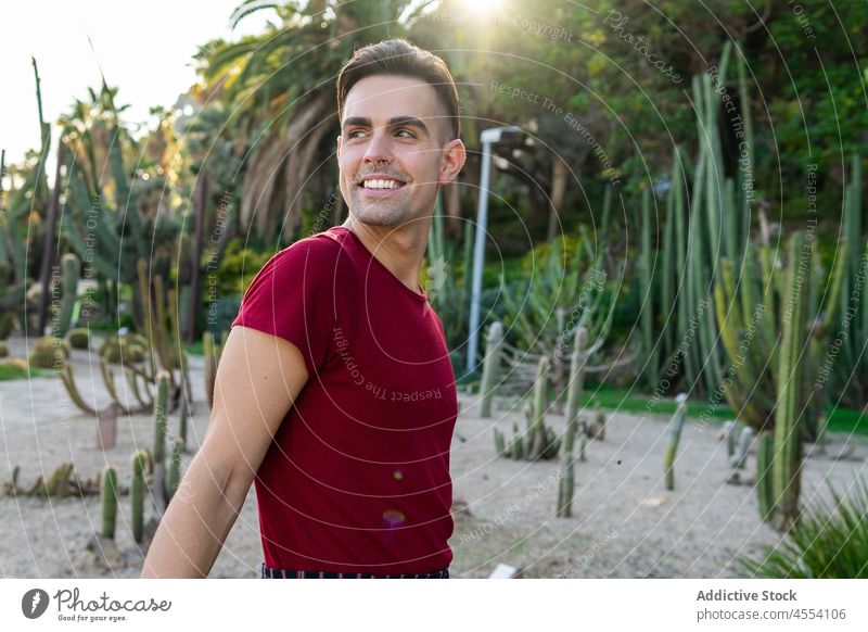 Positive man looking away in tropical garden resort summer holiday vacation exotic confident nature male young ethnic hispanic fit muscular personality model