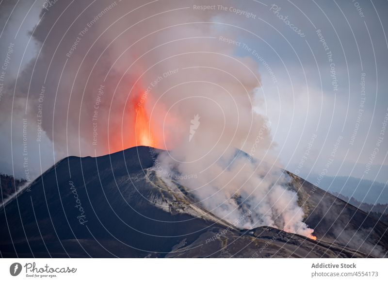 Volcano eruption with thick smoke in Canary Islands mountain volcano magma lava landscape vapor highland range steam slope hot nature fog sky cumbre vieja