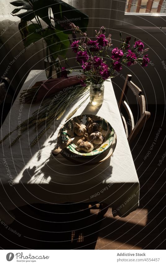 Bowl of garlic near bunch of grass and flowers bowl harvest spike rye bloom rustic countryside vegetable cereal food blossom still life ceramic whole bouquet