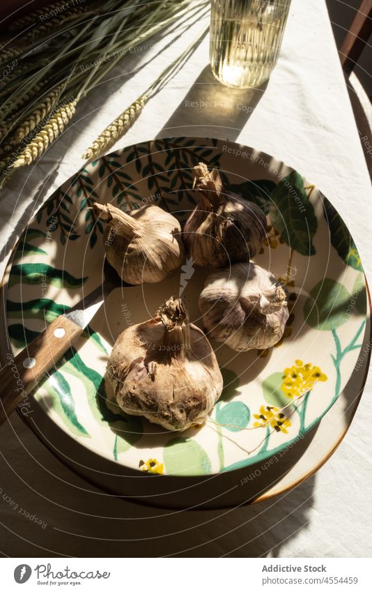 Bowl of garlic near bunch of grass bowl harvest spike rye rustic countryside vegetable cereal food still life ceramic whole rural stem village house twig home