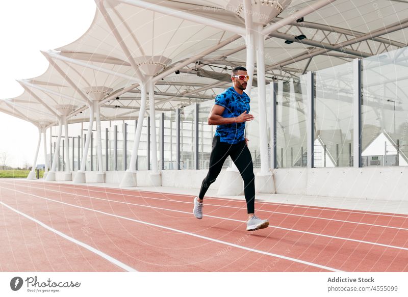 Athletic man running on the running track handsome male ethnic african young adult athlete sportswear runner training exercising fitness exercise healthy