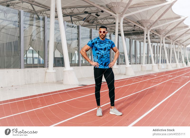 Athletic man standing on the running track handsome young ethnic african american male sunglasses sports clothing athletic lifestyle leisure champion ready