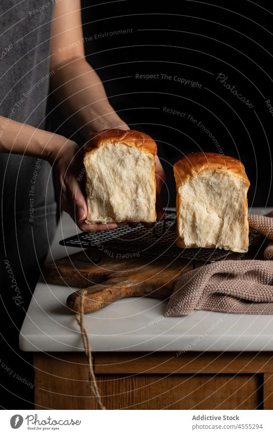 Crop cook with sandwich bread in dark kitchen baker half split tasty baked delicious food loaf appetizing grill yummy nutrition tray counter delectable fresh
