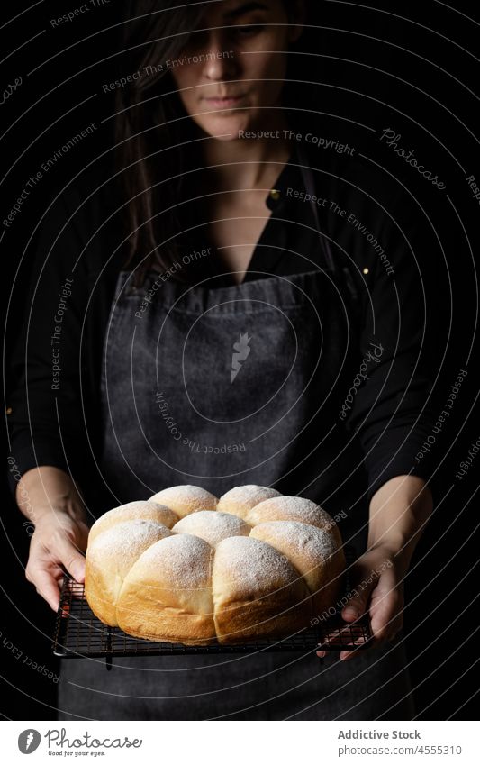 Crop cook with baked buns on grill tray baker woman bread tasty delicious food appetizing chef counter yummy nutrition palatable delectable fresh nutrient