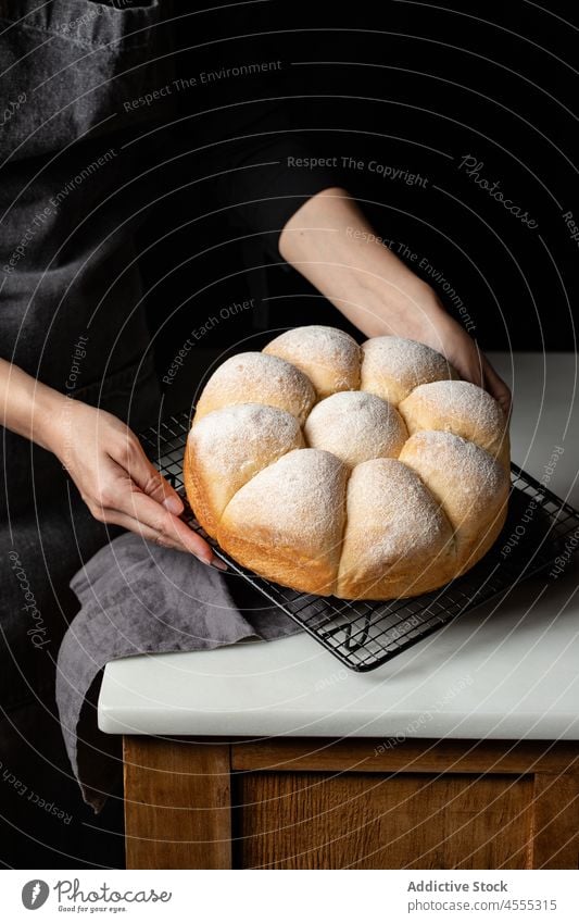 Crop cook with baked buns on grill tray baker bread tasty delicious food appetizing chef counter yummy nutrition palatable delectable fresh nutrient wooden