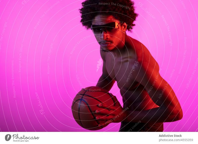 Black shirtless man with basketball sportsman naked torso neon fluorescent muscular appearance individuality male african american black man curly hair young