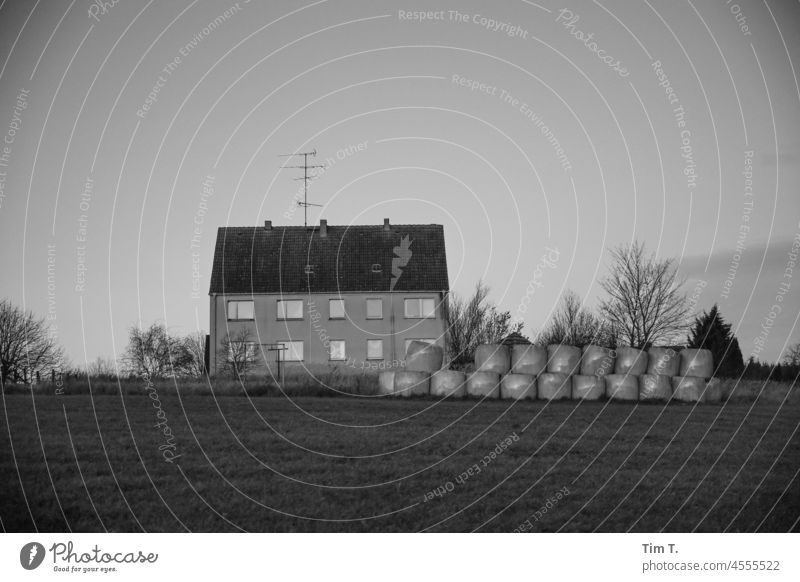 an apartment building on the edge of the field Uckermark b/w Field House (Residential Structure) Bale of straw Black & white photo Architecture Day