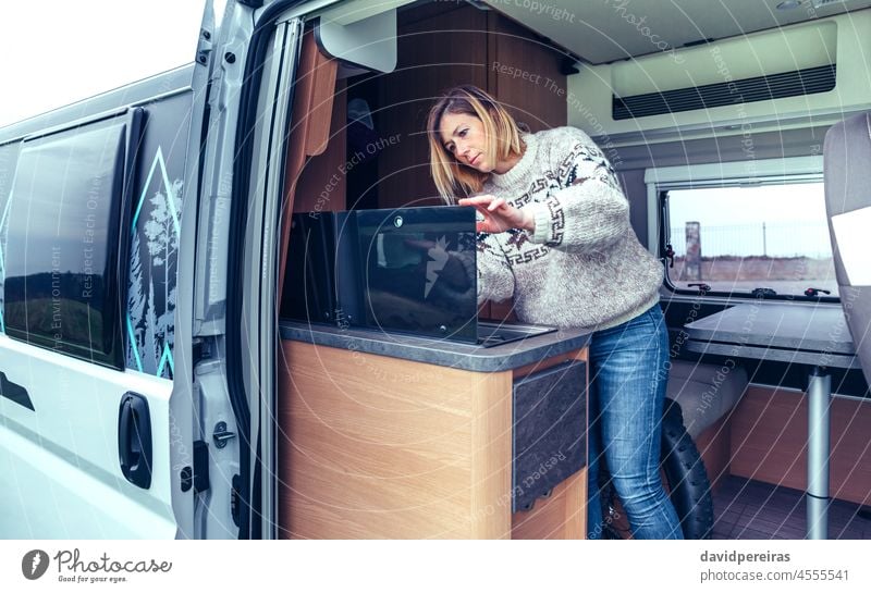 Woman cleaning kitchen of a camper van with a cloth young woman tidy perfectionist hand people female interior automobile cleaner person vehicle rag wipe worker