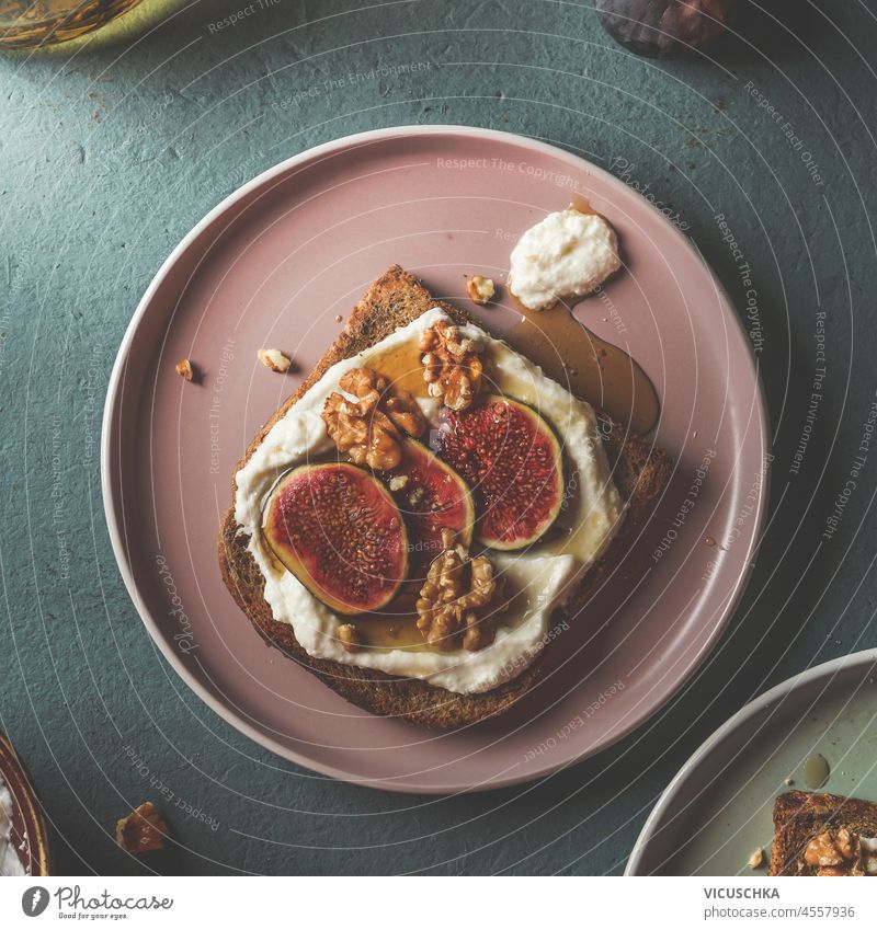 French toast with cream cheese, figs and maple syrup on pale pink plate at blue kitchen table. Healthy vegetarian breakfast idea. Top view. french toast healthy