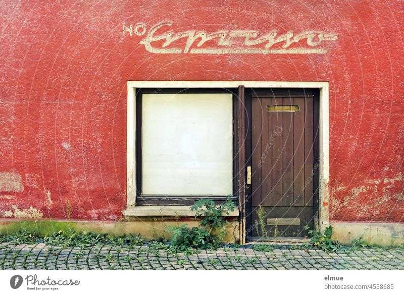 dilapidated building with red paint and a shrouded shop window, an entrance door and above it the writing - HO Espresso - / Lost Place / Tooth of Time Building