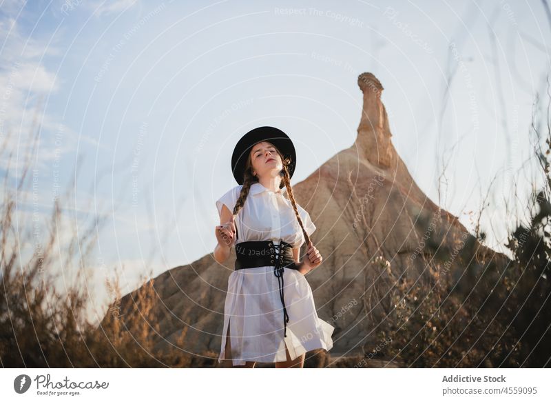 Carefree female with braids near mountain of Bardenas Reales woman spain park nature castelditierra navarra cliff relax rest holding white dress vacation travel
