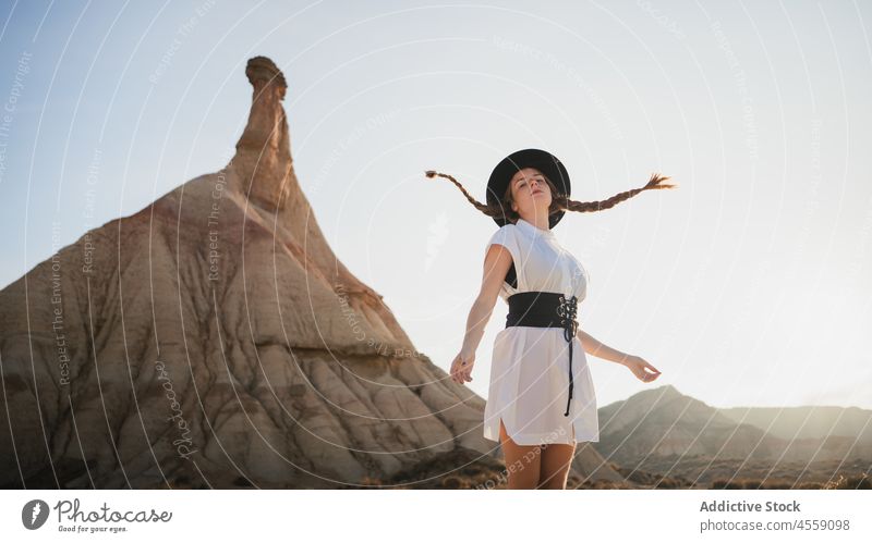 Carefree female with waving braids near mountain of Bardenas Reales woman spain park nature happy castelditierra navarra cliff relax rest white dress vacation