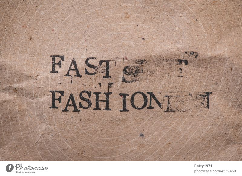 Stamped text on crumpled paper. Almost Fashion. fast fashion blurred Word Environment harmful to the environment Influencer Paper Grunge types stamped