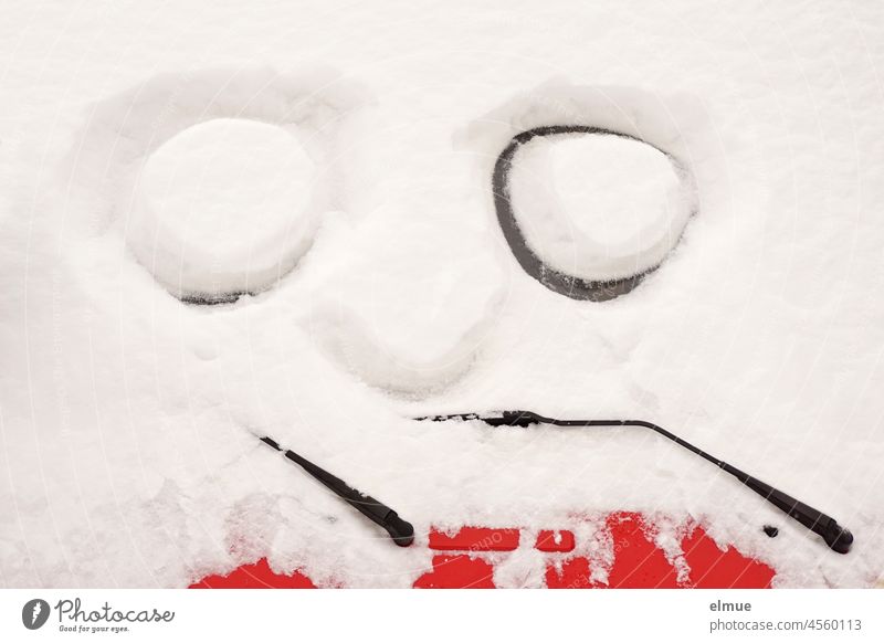Two big eyes and a nose are painted in the snow on the frosty window of a snowed-in red car / Winter / Humor Snow Virgin snow Snow masses Road traffic