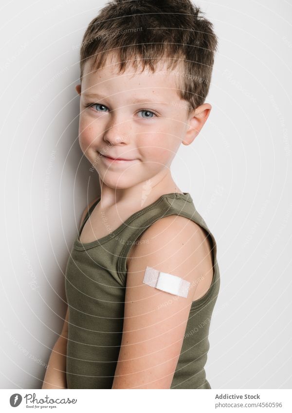 Schoolboy after vaccination with band aid on arm child vaccine jab kid shot injection healthy motivation childhood support medical epidemic schoolkid generation