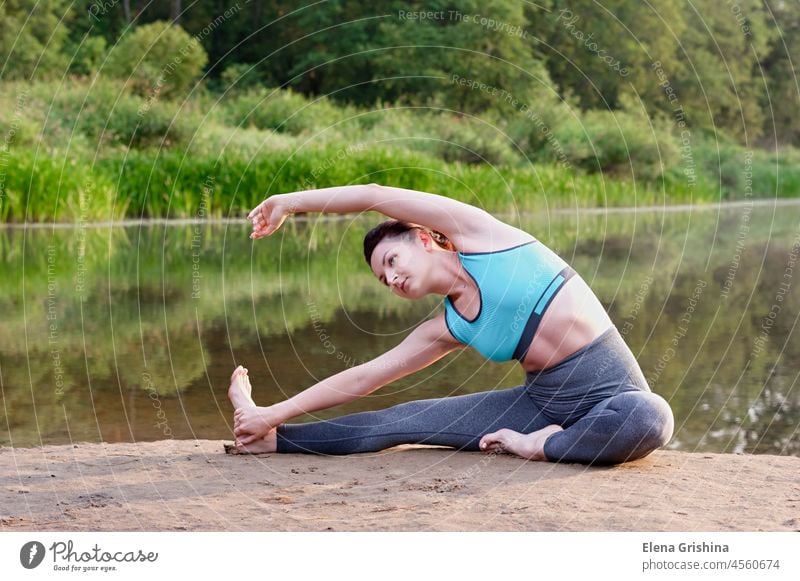 A young girl practices yoga on the lake in the park. Close up. woman nature wellness physical health personal health emotional and spiritual health
