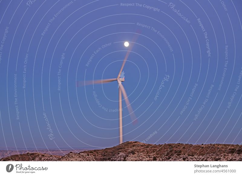 Image of rotating wind turbine in evening light with full moon windmill electricity energy environment renewable power sky nature generator ecology technology