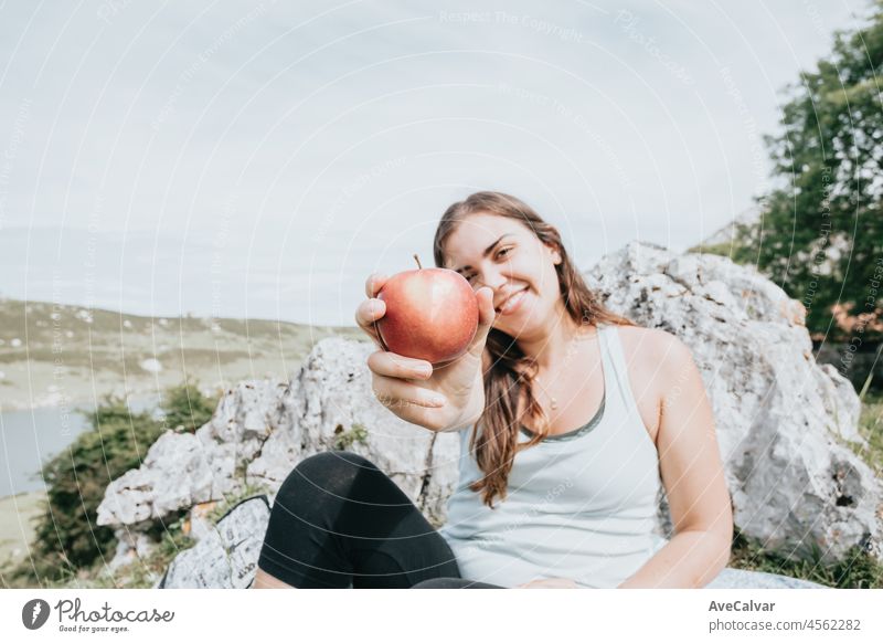 Hiker having a snack eat apple in the mountains, long trail rest, hiking activity, leisure and nature sport. Resting during the route in the lakes. Healthy life style with copy space for text