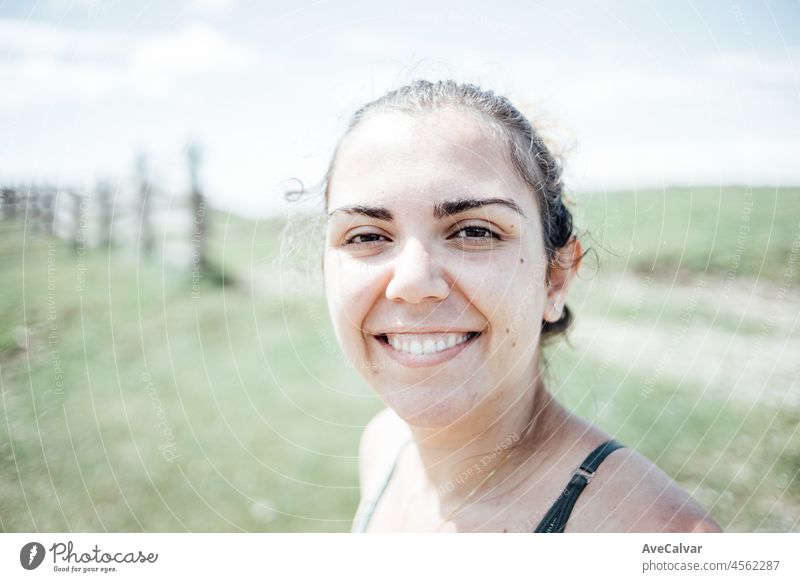 Portrait of a young woman smiling straight to camera after a hiking session on the mountains freedom smile person arms artistic breath breathing brunette