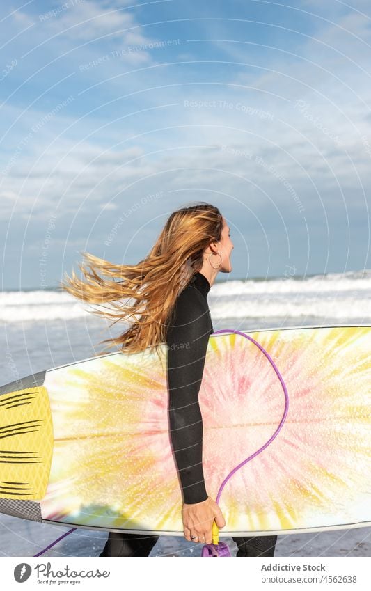 Woman with surfboard walking on wet beach woman coast shore hobby activity pastime sport sea water tide wave waterfront seaside nature seashore equipment summer