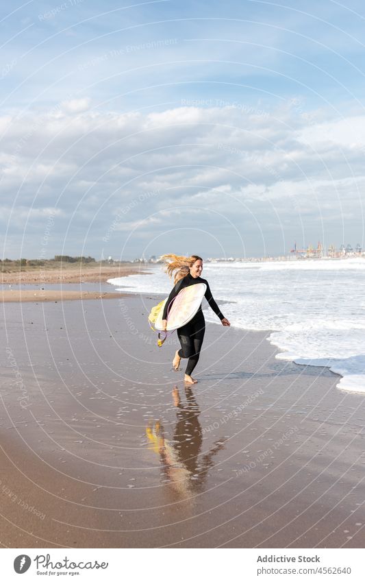 Woman with surfboard running on wet beach woman coast shore hobby freedom activity pastime sport sea water tide wave waterfront seaside nature seashore