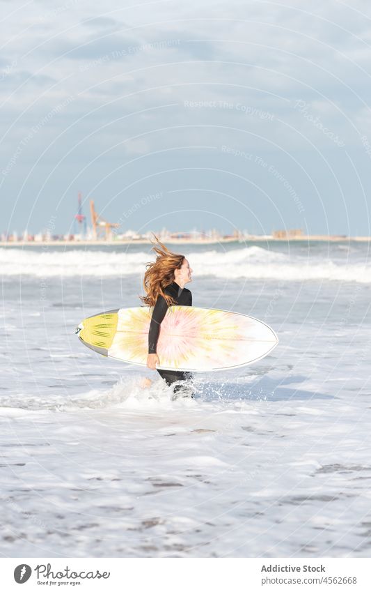 Woman with surfboard running on wet beach woman coast shore hobby freedom activity pastime sport sea water tide wave waterfront seaside nature seashore