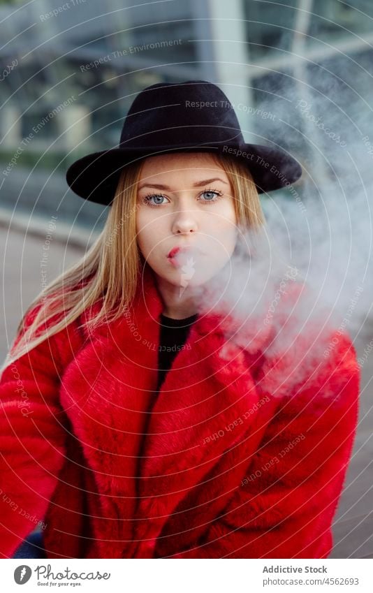Young woman smoking with vaper portrait young vaping adult alternative attractive beautiful blonde blow caucasian cigarette city colorful concept cute