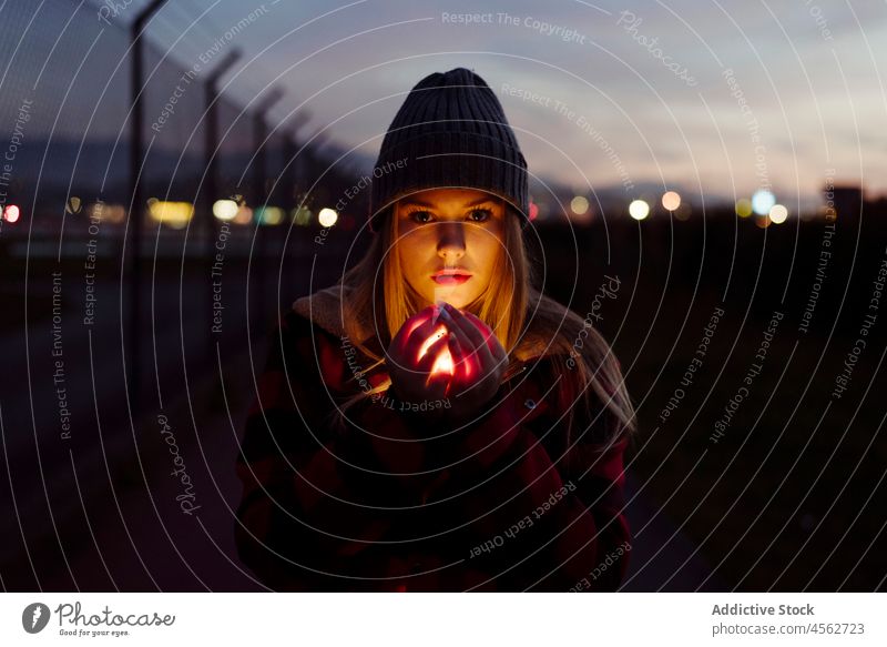 Young woman with wool hat holding a light garland young portrait night attractive autumn blonde bokeh bulbs candid caucasian city creativity cute evening female