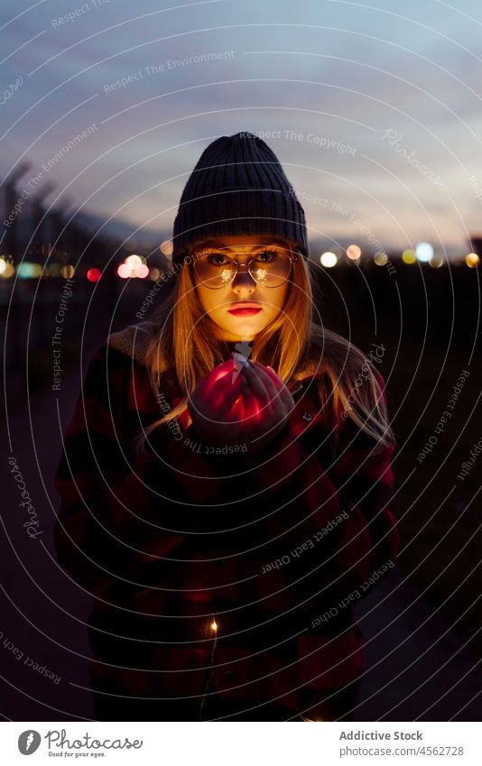 Young woman with wool hat holding a light garland young portrait night attractive autumn blonde bokeh bulbs candid caucasian city creativity cute evening female
