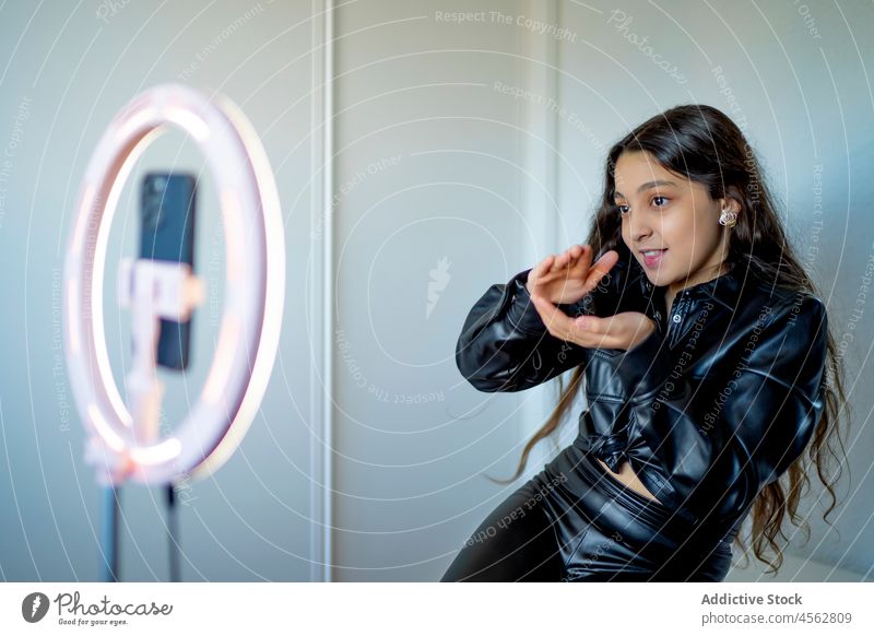 Underage girl using a ring of light to broadcast online on social networks pink style artificial create halo circle futurism artificial intelligence young lamp