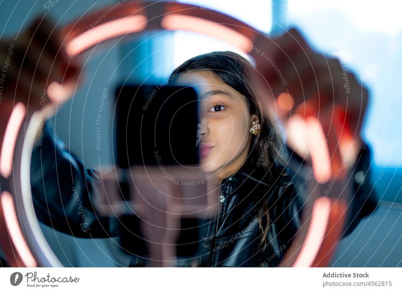 Underage girl using a ring of light to broadcast online on social networks pink style artificial create halo circle futurism artificial intelligence young lamp