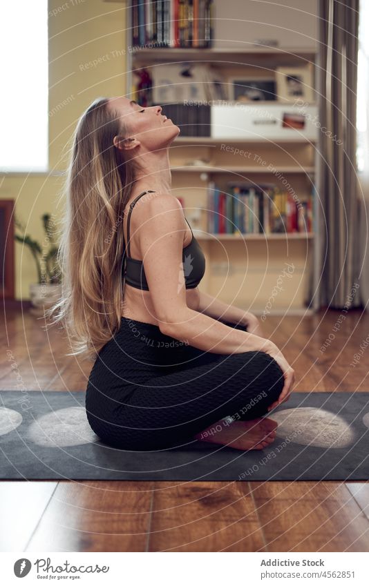Woman sitting on a mat woman yoga training workout healthy lifestyle wellness wellbeing practice living room female slim apartment home sporty lady activity