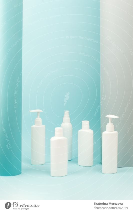 Set of white cosmetic bottles with soft shadows on light blue background. Home and beauty salon care concept, mock up, copy space, beauty industry banner, flyer, coupon, healthcare
