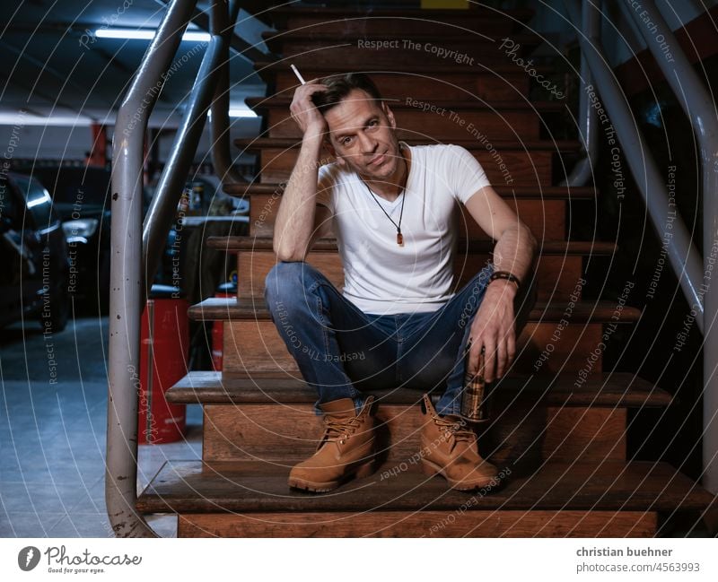 portrait of a 40 year old man in his garage Man 40 years Mechanic Auto repair shop Garage Stairs boats Cool Cigarette sexy cars easy likeable