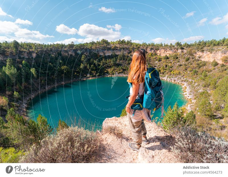 Backpacker admiring view of blue lagoon woman traveler tourist hiker admire cliff scenic explore trekking blue sky contemplate canada del hoyo cuenca spain