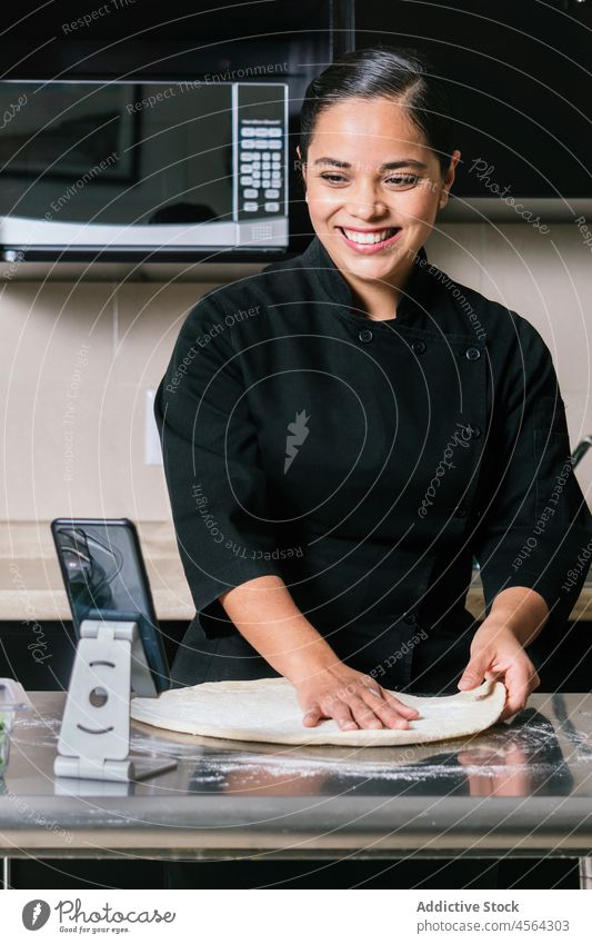 Smiling woman shooting vlog while making pizza cook smartphone kitchen video record culinary gadget process prepare chef food uniform blog using delicious