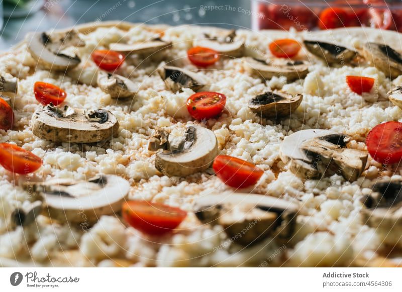 Delicious pizza with mushrooms and cherry tomatoes cheese uncooked raw food sauce delicious meal italian ingredient gastronomy appetizing recipe demonstrate