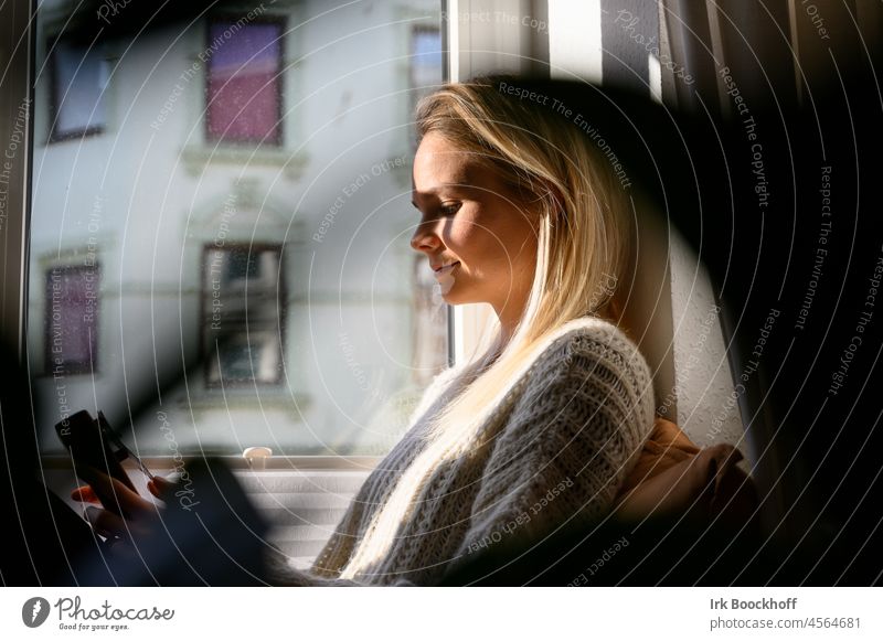 Young woman smiling contentedly at window in the sun deceleration Adults Quarantine Student pretty Lifestyle confident Break relax Attractive Contentment