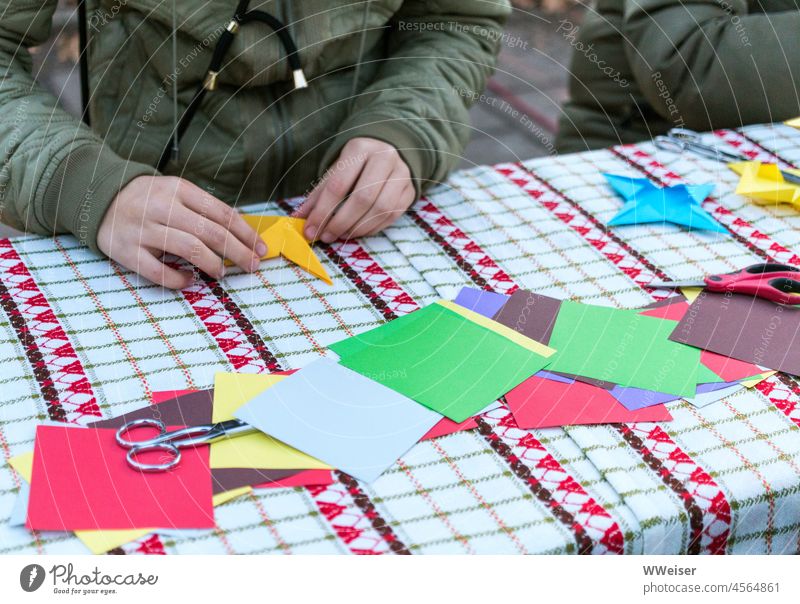Children and adults make colourful paper stars together at the Christmas market Handicraft Paper Markets Handicraft stand Stars Christmas Fair Advent Cold