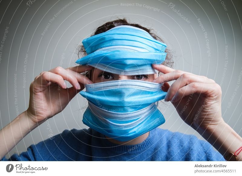 A woman covers her face with several medical masks covid virus female epidemic freedom restriction lockdown prohibition isolation quarantine observation strain