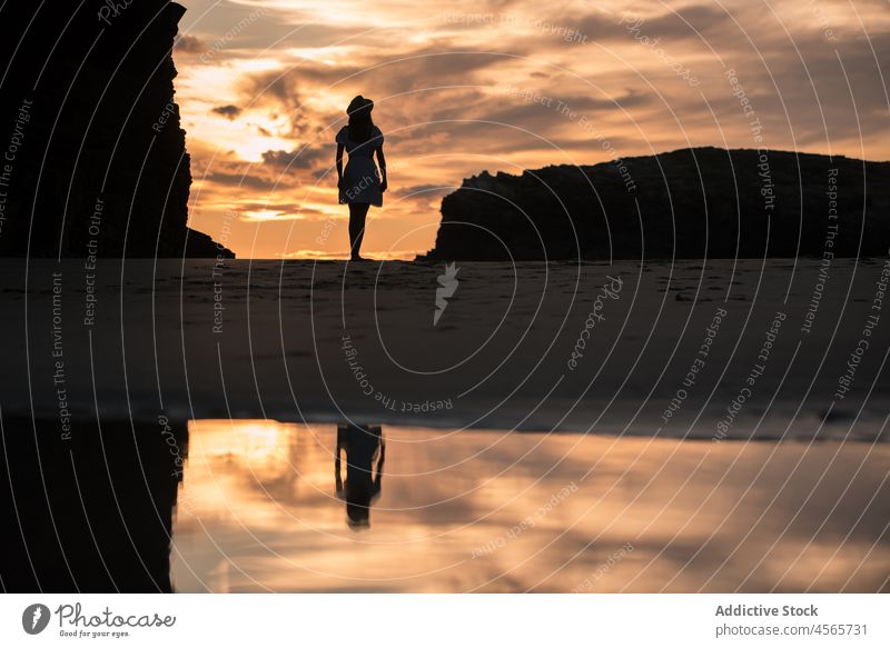 Lady standing on beach against sundown woman silhouette sunset sea shore twilight cliff picturesque beach of the cathedrals galicia spain enjoy female seascape