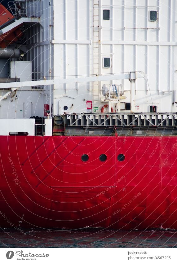 Cargo ship with portholes from large freighter in red + white ship's side Detail Structures and shapes Authentic Ship's side Porthole Maritime Logistics Hull